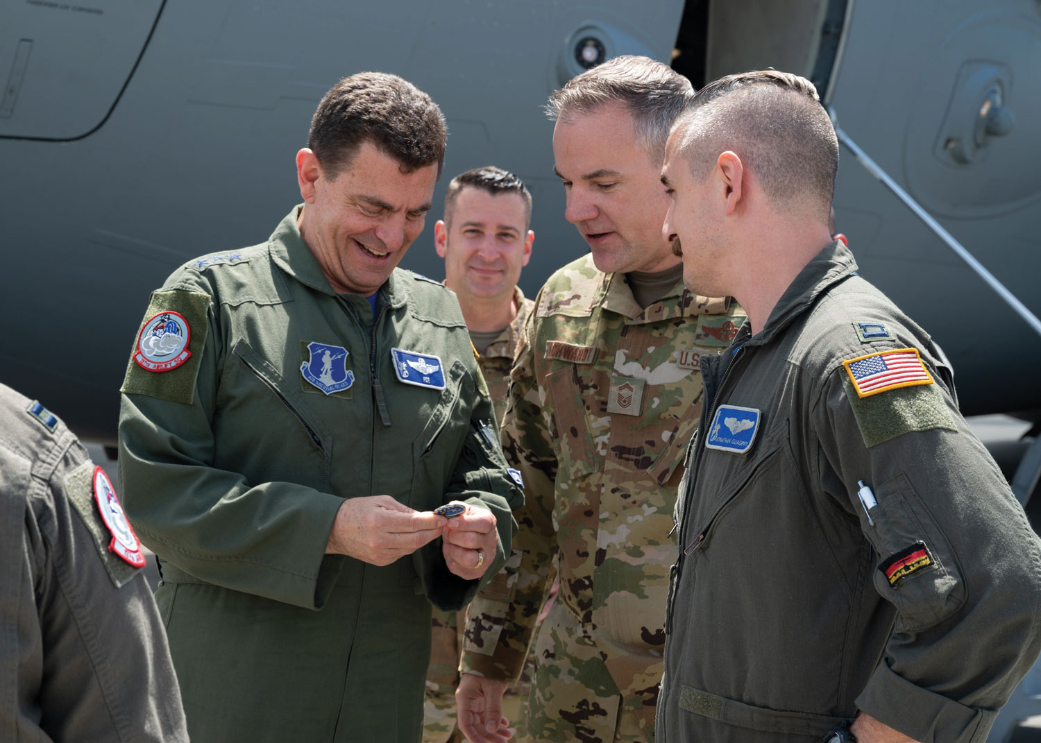 Loh (left) examines a challenge coin he received from Senior Master Sgt. Krystopher L. Schwandt, a member of the New York Air Guard’s 105th Airlift Wing, while visiting Stewart Air National Guard Base, Newburgh, New York, June 3.