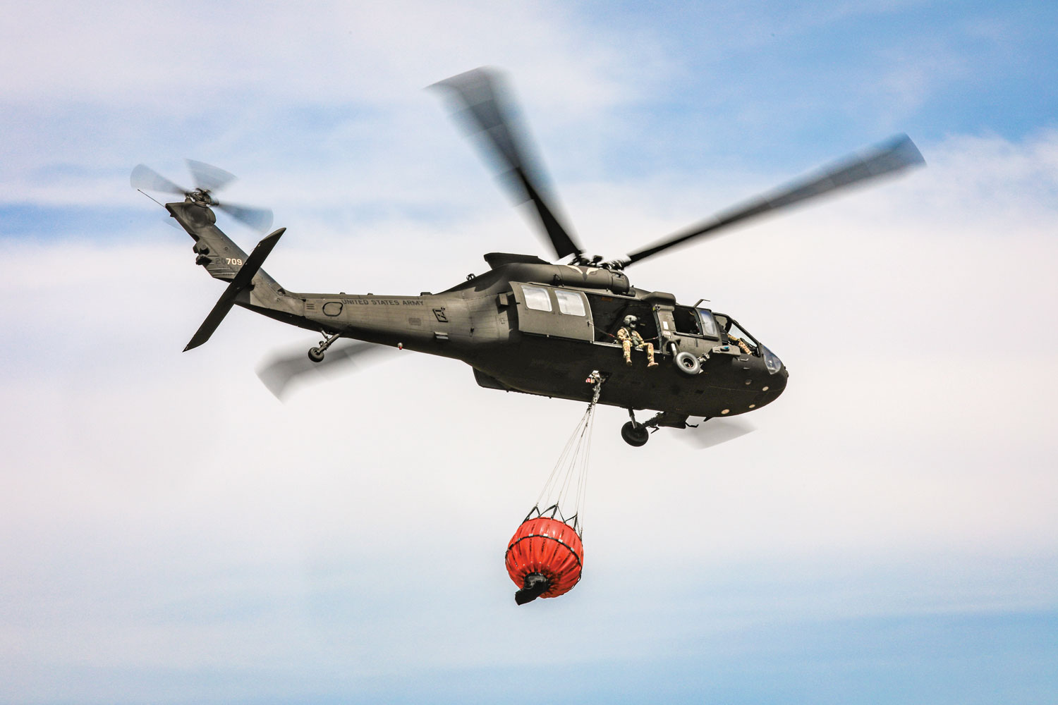 An Oklahoma Army Guard UH-60 Black Hawk helicopter crew flies over the 702 Fire in Blaine County, Oklahoma, after dropping more than 600 gallons of water on the stubborn wildfire.